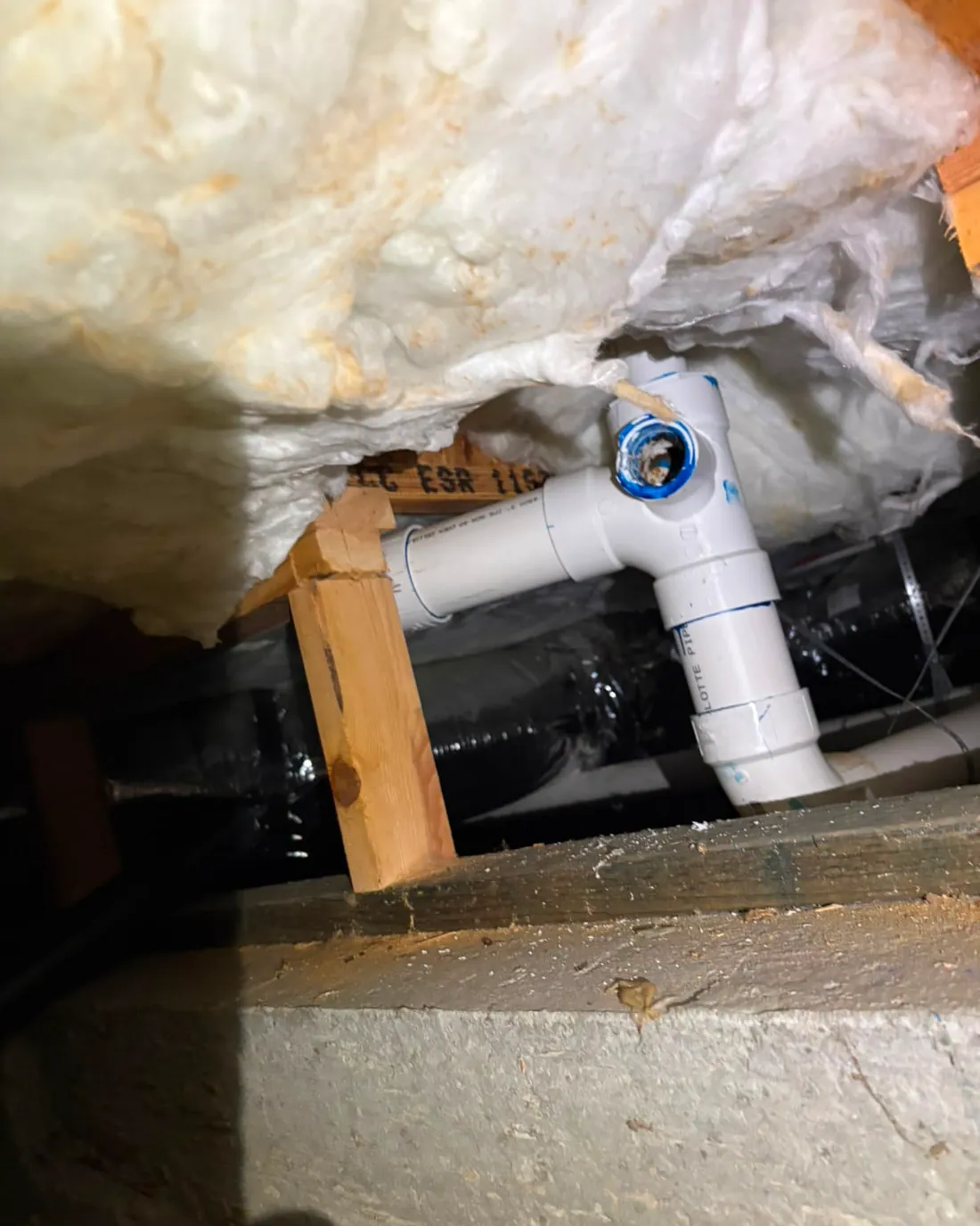 Water supply line left exposed below the insulation in a crawlspace