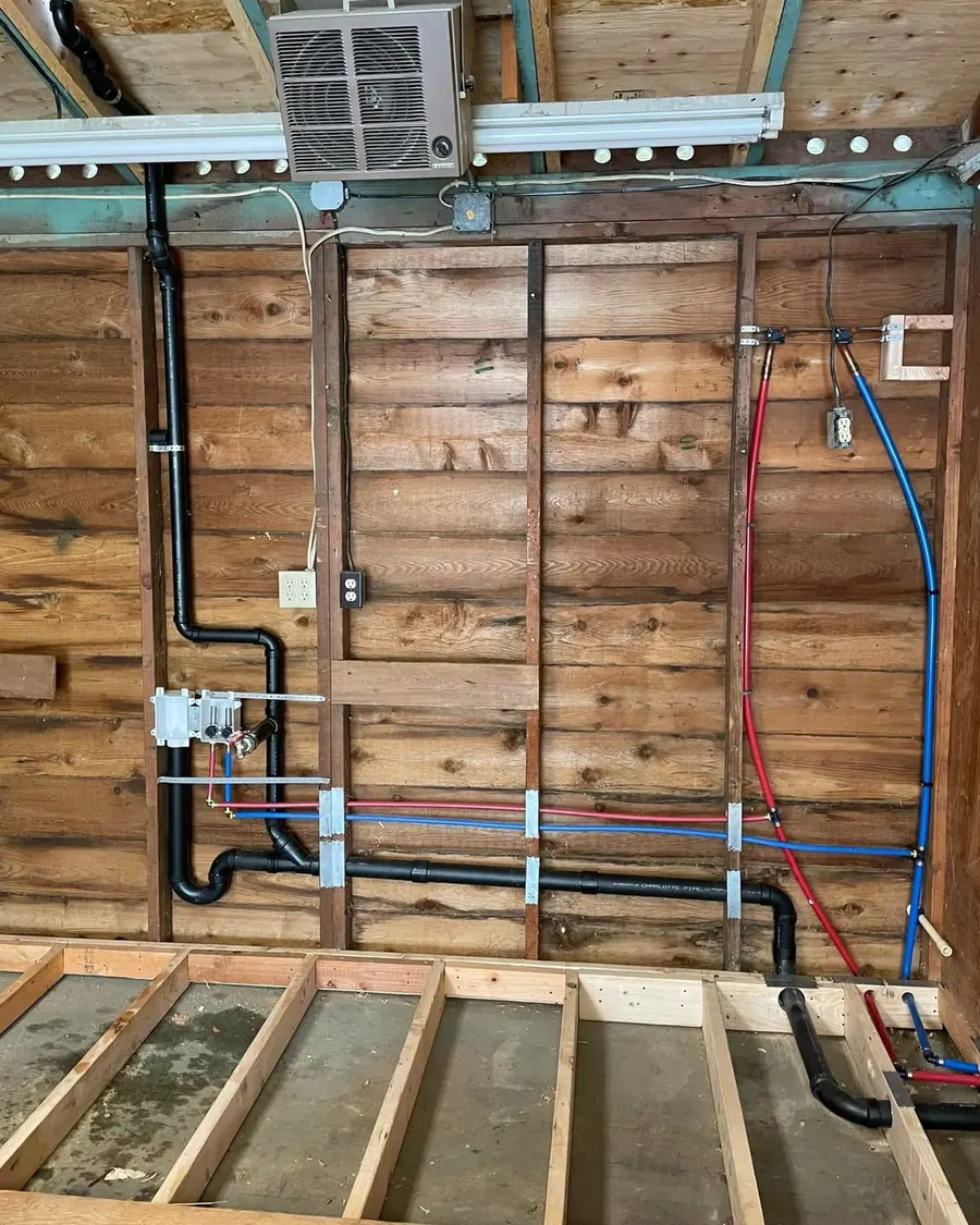 Full PEX repipe with new ABS drain stack on an open garage wall