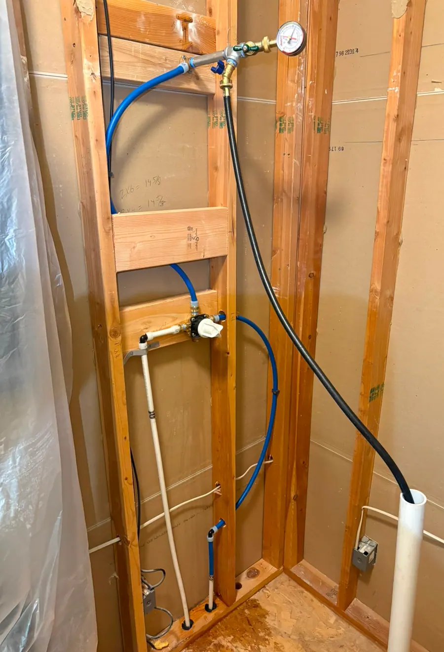 Bathroom rough-in with PEX supply lines under pressure test