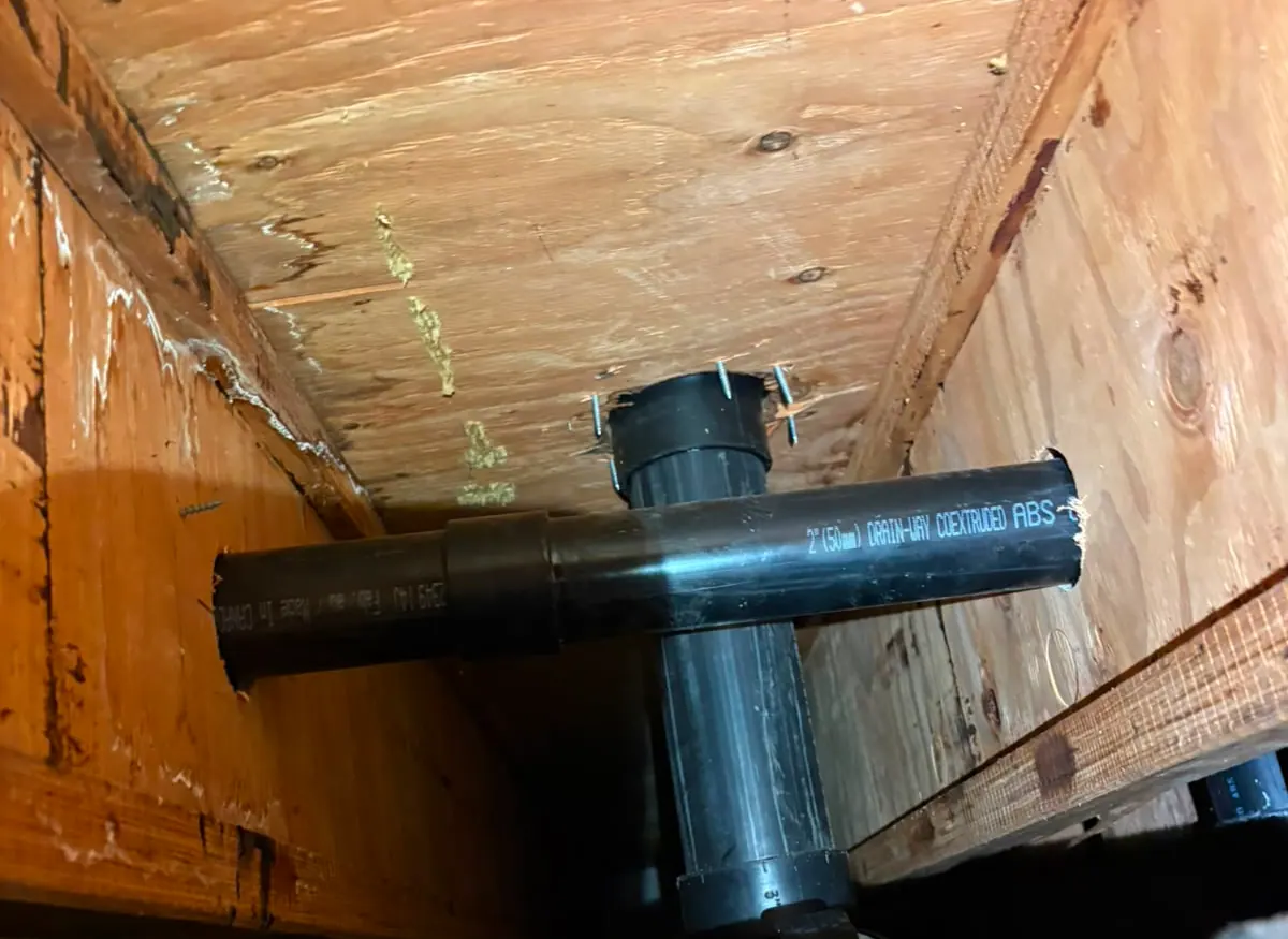 ABS sanitary tee and vent branch in a crawlspace
